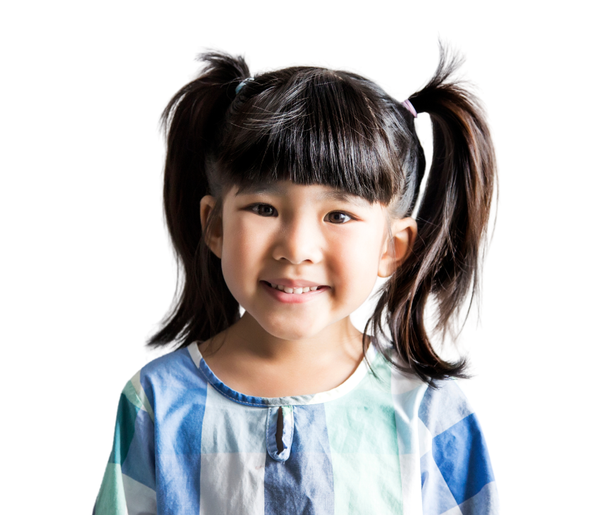 Smiling young girl with dark hair in pigtails, wearing a blue and white checkered shirt, standing against a plain white background.